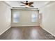 Empty main bedroom featuring a tray ceiling, hardwood floors, and abundant natural light at 13811 Waverton Ln, Huntersville, NC 28078