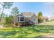 A rear view featuring a screened in back porch, stairs, and a green lawn at 165 Blue Ridge Trl, Mooresville, NC 28117