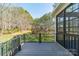 Wooden back porch with black aluminum railing overlooking the backyard and trees at 165 Blue Ridge Trl, Mooresville, NC 28117