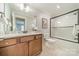 Well-lit bathroom showcasing a vanity, framed mirror, and a shower-tub combination with a glass enclosure at 165 Blue Ridge Trl, Mooresville, NC 28117