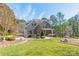 Beautiful home with lush landscaping, stone accents, and a welcoming covered porch with seating at 165 Blue Ridge Trl, Mooresville, NC 28117
