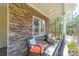 Charming porch with stone accents, comfortable seating, and a view to the private yard for relaxing outdoors at 165 Blue Ridge Trl, Mooresville, NC 28117