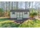Outdoor shed with double doors and small windows surrounded by trees and grass at 165 Blue Ridge Trl, Mooresville, NC 28117