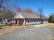 Charming single-story home featuring a covered porch and a gravel driveway for ample parking at 1806 Bringle Ferry Rd, Salisbury, NC 28146