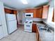 Well-lit kitchen with white appliances, wood cabinets, and views from the window at 1806 Bringle Ferry Rd, Salisbury, NC 28146