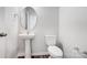 Half bathroom featuring a pedestal sink, modern toilet, and round mirror in a neutrally painted room at 2320 Hedgecliff Rd # 158, Kannapolis, NC 28025