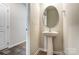 A modern powder room with a stylish pedestal sink and a round mirror at 2330 Hedgecliff Rd # 157, Kannapolis, NC 28025