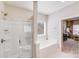 Bright bathroom featuring a glass shower, soaking tub, and access to the main bedroom at 245 Pine Eagle Dr, Rock Hill, SC 29732