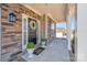 Inviting front porch with stone accents, a decorative wreath on the front door, and manicured potted plants at 245 Pine Eagle Dr, Rock Hill, SC 29732
