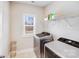 Well-lit laundry room with modern washer and dryer, built in shelf storage, and a window at 245 Pine Eagle Dr, Rock Hill, SC 29732