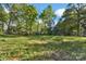 Picture of a beautiful backyard of a property surrounded by a border of trees and green grass at 265 Duke Dr, Salisbury, NC 28146
