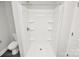 Bright white bathroom with a standing shower, shelves, and toilet at 265 Duke Dr, Salisbury, NC 28146