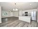 Open-concept kitchen features an island, granite countertops, stainless appliances, and gray wood floors at 265 Duke Dr, Salisbury, NC 28146