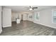 Bright open-concept living room with grey wood-look flooring, neutral paint, and views to kitchen at 265 Duke Dr, Salisbury, NC 28146