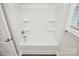 A white shower and tub combo featuring built-in shelving and a chrome faucet at 265 Duke Dr, Salisbury, NC 28146