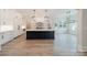 Open kitchen featuring a large island, modern lighting, stainless appliances, and hardwood floors at 310 Sugar Maple Ln, Weddington, NC 28104