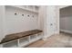 Mudroom with built-in bench, storage cubbies, shiplap accents, and hardwood floors at 310 Sugar Maple Ln, Weddington, NC 28104