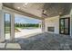 Covered patio with stone floor, fireplace, and view of the pool and yard at 310 Sugar Maple Ln, Weddington, NC 28104