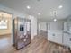 Open concept kitchen with stainless steel fridge, hardwood floors, white cabinets and modern lighting at 337 Glenwood Dr, Mooresville, NC 28115