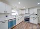 Bright kitchen features white cabinets, granite countertops, stainless appliances and hardwood floors at 337 Glenwood Dr, Mooresville, NC 28115