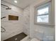 Bright, tiled walk-in shower featuring a window and niche for storage at 337 Glenwood Dr, Mooresville, NC 28115