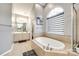 Bright bathroom featuring a soaking tub under an arched window and a large vanity with double sinks at 341 Fischer Rd, Fort Mill, SC 29715