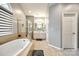 Bright bathroom with a soaking tub, glass enclosed shower and beige tile at 341 Fischer Rd, Fort Mill, SC 29715