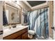 Bathroom with wood vanity, patterned shower curtain, and decorative mirror providing a warm and inviting space at 341 Fischer Rd, Fort Mill, SC 29715