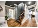 Hallway with dark ceiling, elegant stairway, wood floors and white wainscoting creates a modern feel at 341 Fischer Rd, Fort Mill, SC 29715