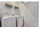 Bright laundry room with a modern washer, dryer, and shelving for organized storage at 348 Catawba Ave, Davidson, NC 28036