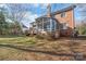 Backyard featuring a sunroom addition to the home, a deck, and a well-maintained lawn at 5101 Belicourt Dr, Charlotte, NC 28277