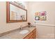This bathroom includes a vanity with granite countertop, sink, and a framed mirror at 5101 Belicourt Dr, Charlotte, NC 28277