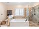 This primary bathroom includes a soaking tub, glass shower, and decorative tile at 5101 Belicourt Dr, Charlotte, NC 28277