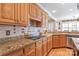 Kitchen features wooden cabinets, granite countertops, and modern appliances with tile backsplash at 5101 Belicourt Dr, Charlotte, NC 28277