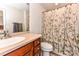 This bathroom includes wood cabinets, a tile floor, and a patterned shower curtain at 599 Sixth Baxter Xing, Fort Mill, SC 29708