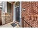 Close-up of a brick house featuring a black door, elegant white trim, and black iron railing at 599 Sixth Baxter Xing, Fort Mill, SC 29708