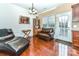 This living space features wood floors, a ceiling fan, and a glass panel door to the backyard at 599 Sixth Baxter Xing, Fort Mill, SC 29708