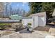 Outdoor seating area with a dining table, umbrella, and a storage shed, perfect for outdoor relaxation at 7200 Morning Dew Ct, Denver, NC 28037