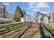 Landscaped backyard featuring a greenhouse, lush greenery, and mature trees providing shade and privacy at 7200 Morning Dew Ct, Denver, NC 28037