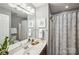 Well-lit bathroom features a double vanity, a large mirror, and a shower with a stylish curtain at 7200 Morning Dew Ct, Denver, NC 28037