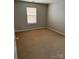 Neutral-toned bedroom featuring a window with blinds and neutral carpet at 8833 Goldfields Dr, Charlotte, NC 28227