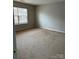 Spacious bedroom with neutral walls, a window with blinds, and neutral carpet at 8833 Goldfields Dr, Charlotte, NC 28227