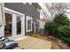 Backyard view showcasing a patio, lush shrubbery, and the exterior of the home with gray siding at 1019 Archibald Ave, Fort Mill, SC 29708