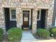 Charming front entrance with stone pillars, a wood door, and manicured bushes and a small garden at 1019 Archibald Ave, Fort Mill, SC 29708