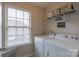 Well-lit laundry room equipped with a washer, dryer, and storage, with a window providing natural light at 1019 Archibald Ave, Fort Mill, SC 29708