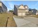 View of the driveway, two car garage and side of a beige home with red shutters at 111 Chaffee Pl, Mooresville, NC 28115