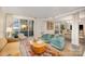 Bright living room with hardwood floors, cozy seating, and a sliding glass door to a private balcony at 1300 Reece Rd # 200, Charlotte, NC 28209