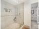Walk-in shower with mosaic tile accents, convenient shelving, and a glass door at 1300 Reece Rd # 200, Charlotte, NC 28209