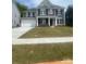Charming two-story home featuring a wide driveway, a two-car garage, and a well-manicured lawn at 138 Nicholson Ln, Mooresville, NC 28115