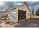 Exterior view of detached garage in need of repair and clean up on a sunny day at 148 Linwood Dr, Albemarle, NC 28001